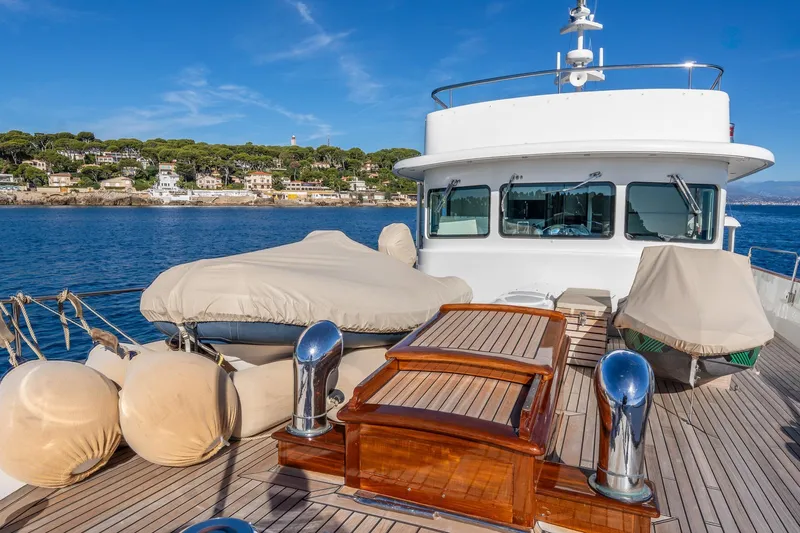 Sultana Yacht Photos Pics Vintage 1969 Feadship 25.8m yacht deck with scenic coastal backdrop.