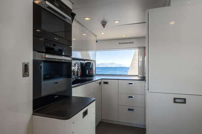 Sultana Yacht Photos Pics Modern kitchen interior on 1969 Feadship 25.8m yacht with ocean view.