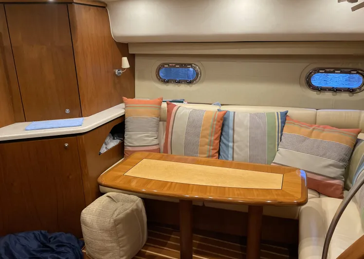 Lion Around Yacht Photos Pics 2006 Tiara Yachts 4300 Sovran interior with striped cushions and wooden table.