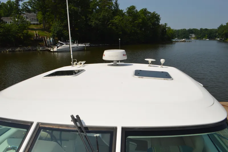 Lion Around Yacht Photos Pics 2006 Tiara Yachts 4300 Sovran on a serene river with lush greenery.