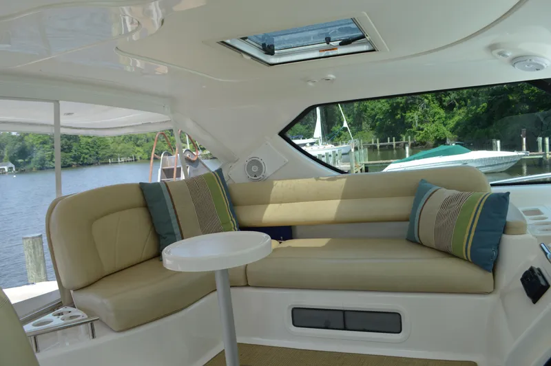 Lion Around Yacht Photos Pics 2006 Tiara Yachts 4300 Sovran interior with beige seating, small table, and scenic water view.