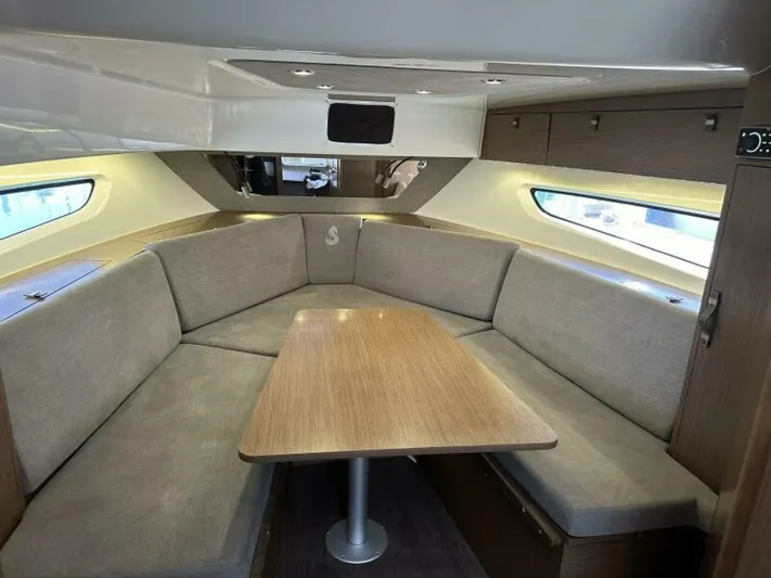 Debbie Yacht Photos Pics Interior of 2021 Beneteau Gran Turismo 32 with cozy seating and wooden table.