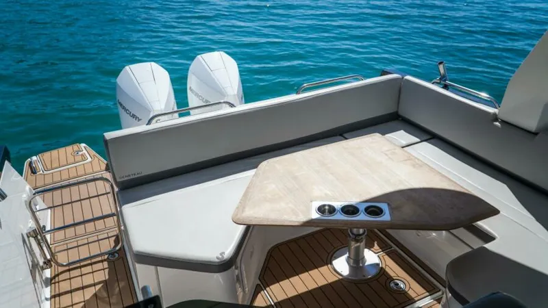 Debbie Yacht Photos Pics 2021 Beneteau Gran Turismo 32 yacht interior with seating and table, overlooking blue water.