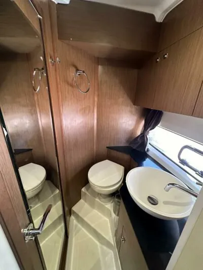 Debbie Yacht Photos Pics 2021 Beneteau Gran Turismo 32 bathroom with wood finish, sink, and toilet.