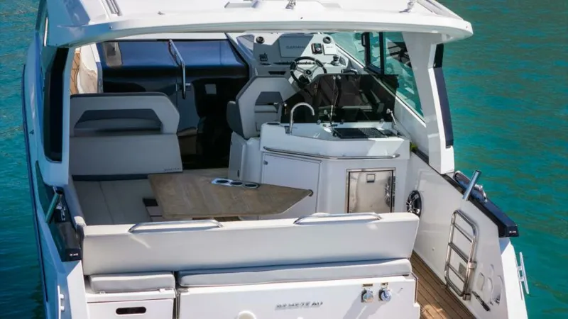 Debbie Yacht Photos Pics 2021 Beneteau Gran Turismo 32 yacht interior with seating and helm, on clear water.