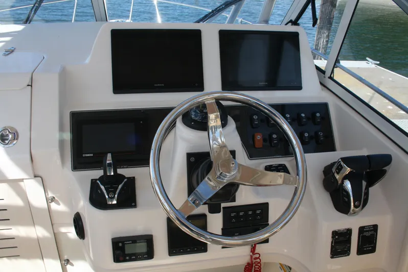 Monkey King Yacht Photos Pics Helm of 2021 Grady-White 232 Gulfstream boat with steering wheel and control panels.