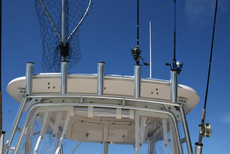 Monkey King Yacht Photos Pics Fishing rods and net on a 2021 Grady-White 232 Gulfstream boat against a clear blue sky.
