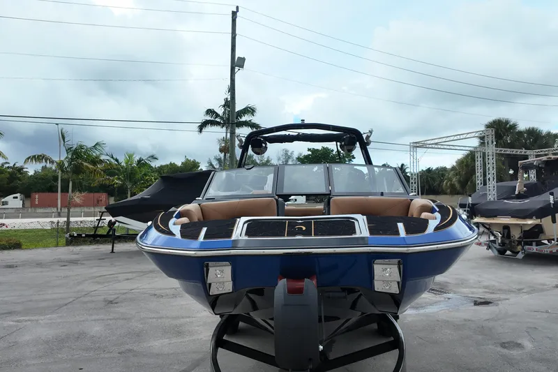  Yacht Photos Pics 2025 Centurion Fe23 boat with sleek design, parked outdoors on a cloudy day.