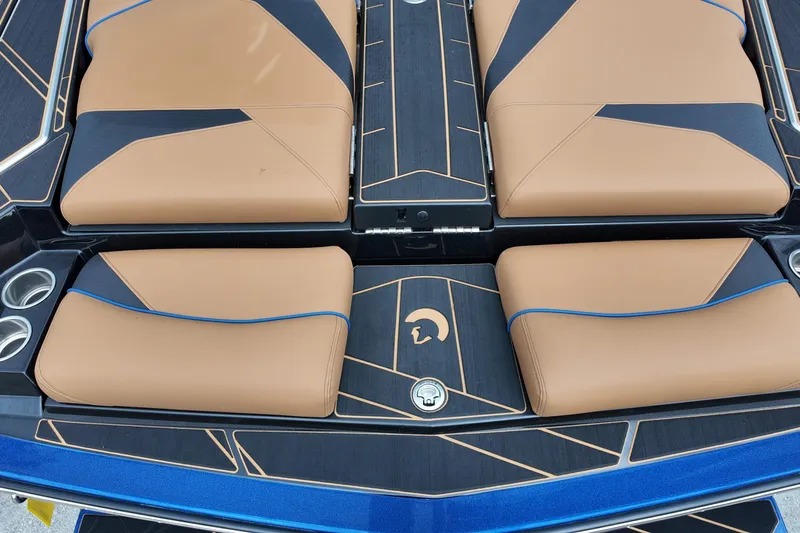  Yacht Photos Pics 2025 Centurion Fe23 boat interior with tan and black seating, blue accents, and cup holders.