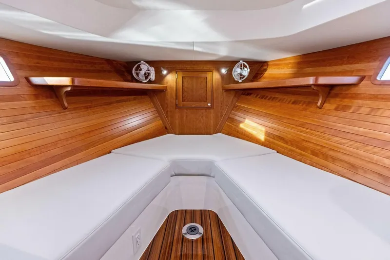  Yacht Photos Pics Luxurious 2025 MJM 35 yacht interior with wooden finish and white cushions.