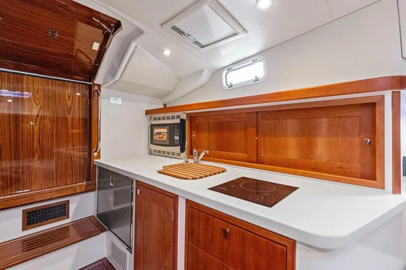  Yacht Photos Pics Modern galley kitchen in 2025 MJM 35 boat with wood accents and sleek appliances.