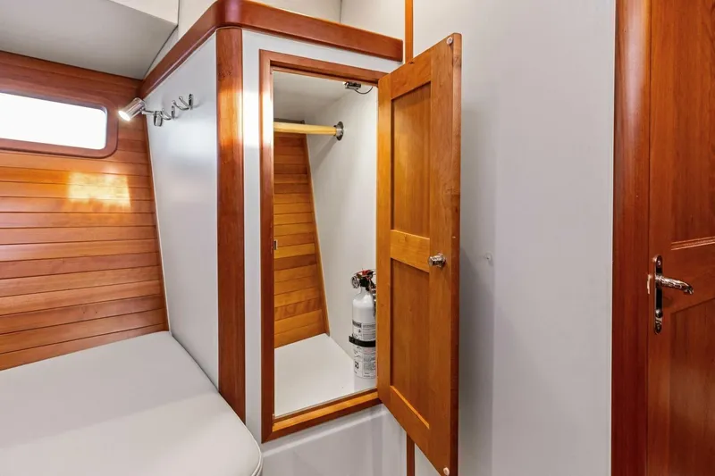  Yacht Photos Pics 2025 MJM 35 yacht interior with wooden cabinetry and storage compartment.