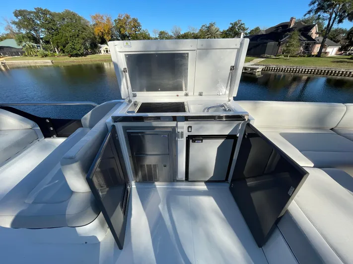  Yacht Photos Pics 2017 Fairline Squadron 48 yacht outdoor kitchen with open cabinets by a serene waterfront.