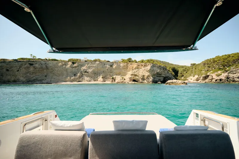  Yacht Photos Pics Luxury view from 2018 Fjord 52 Open yacht, overlooking turquoise waters and rocky coastline.