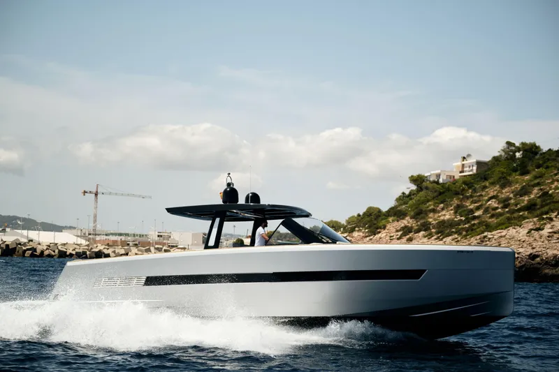  Yacht Photos Pics 2018 Fjord 52 Open yacht cruising near rocky coastline under clear sky.