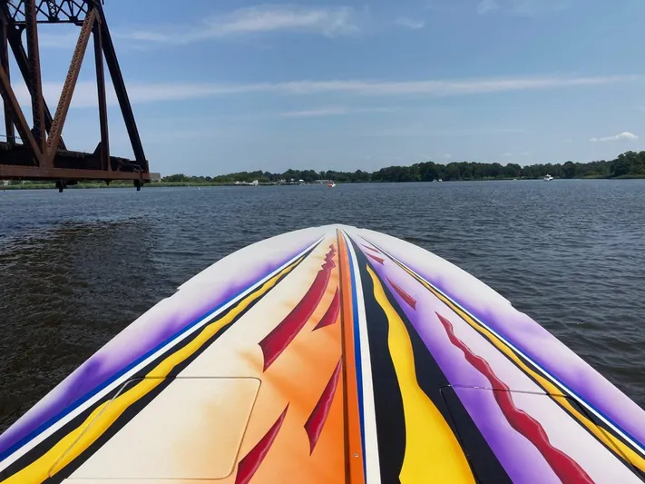  Yacht Photos Pics Colorful 2001 Cigarette 46 Rough Rider boat on a lake under a clear sky.