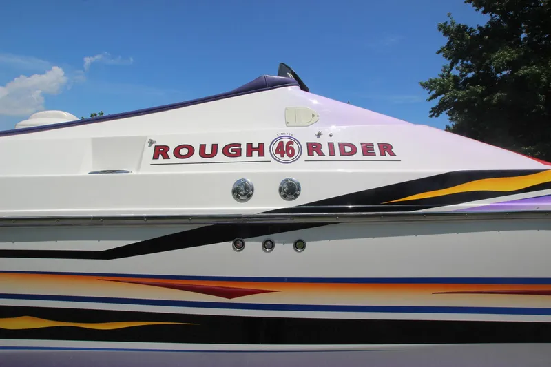  Yacht Photos Pics 2001 Cigarette 46 Rough Rider boat with colorful stripes and logo on the side.