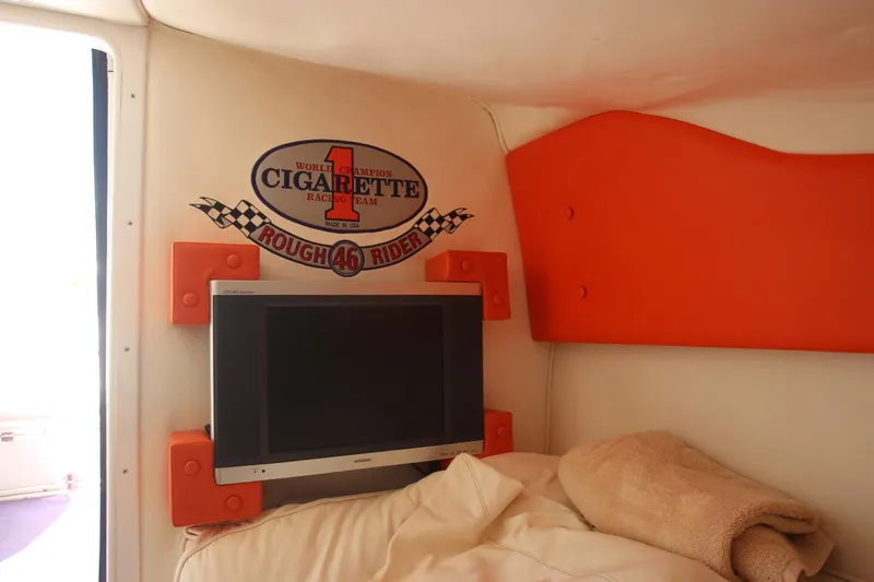  Yacht Photos Pics Interior of 2001 Cigarette 46 Rough Rider boat with TV and logo on wall.