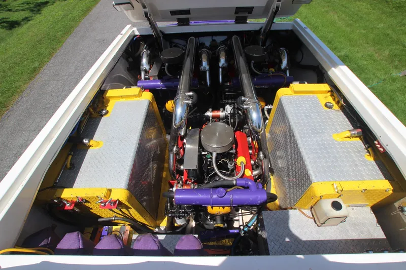  Yacht Photos Pics Engine compartment of a 2001 Cigarette 46 Rough Rider boat, featuring vibrant yellow and purple components.