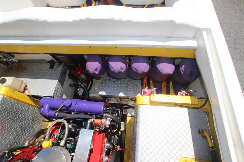  Yacht Photos Pics Engine compartment of 2001 Cigarette 46 Rough Rider boat with purple accents and diamond plate flooring.