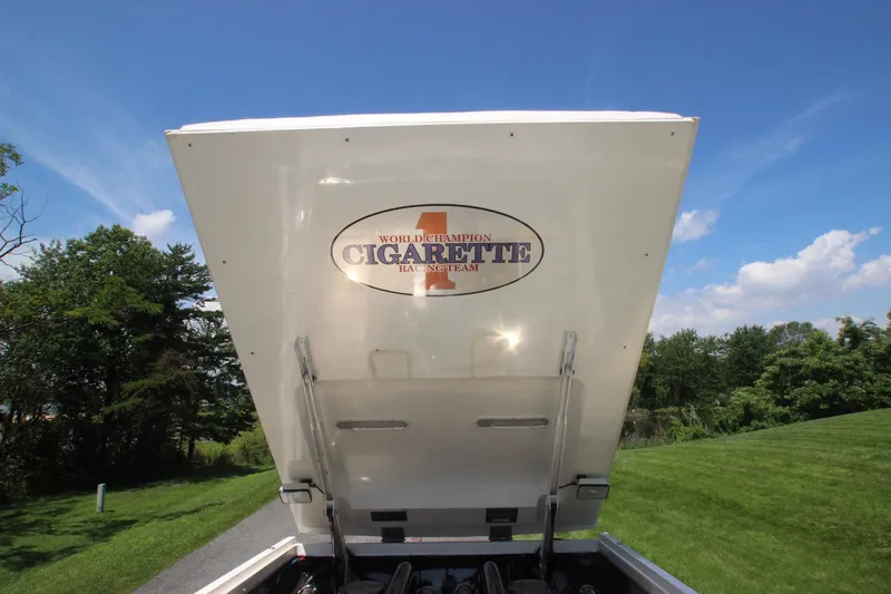 Yacht Photos Pics 2001 Cigarette 46 Rough Rider boat engine cover open, showcasing logo, against a clear blue sky.