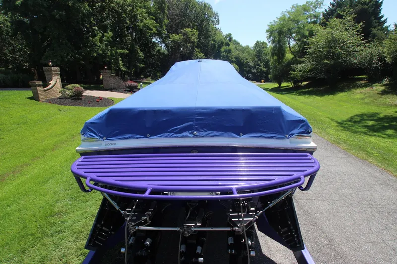  Yacht Photos Pics Covered 2001 Cigarette 46 Rough Rider boat on a driveway, surrounded by greenery.