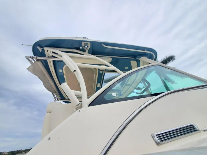 Rising Sun Yacht Photos Pics 2018 Grady-White Express 330 boat with blue canopy and sleek design against cloudy sky.