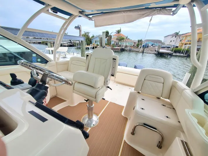 Rising Sun Yacht Photos Pics 2018 Grady-White Express 330 boat interior with helm and seating, docked by waterfront homes.