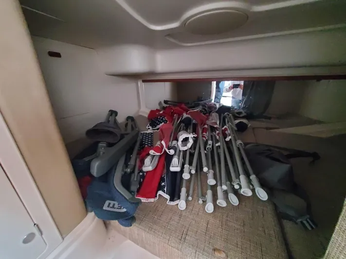 Rising Sun Yacht Photos Pics Storage area inside 2018 Grady-White Express 330 boat, filled with folded chairs and equipment.