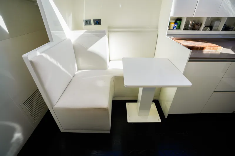 Toro Yacht Photos Pics Modern white dining nook on 2017 Ferretti Yachts 850, featuring sleek table and seating.