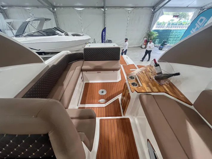  Yacht Photos Pics 2025 Ventura DayCruiser interior with luxurious seating and wooden accents in a showroom.