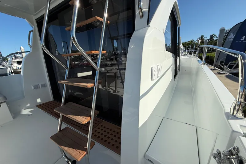  Yacht Photos Pics 2026 Beneteau Antares 12 yacht with sleek design, featuring a wooden ladder and spacious deck.