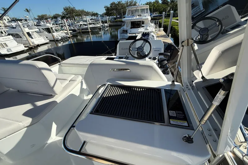  Yacht Photos Pics 2026 Beneteau Antares 12 yacht interior with seating and steering wheel at marina.