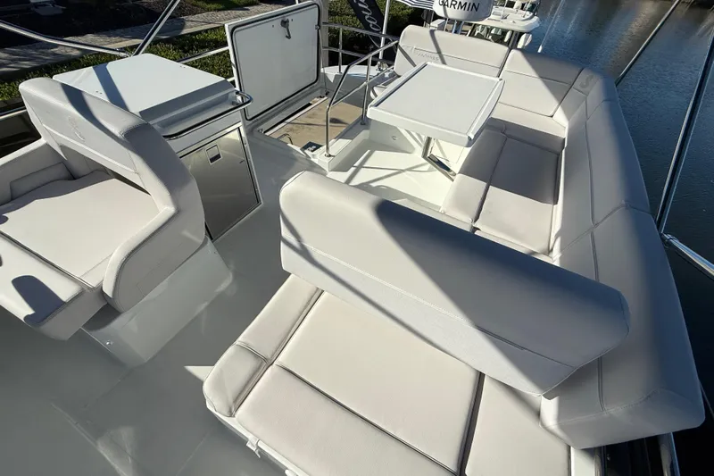  Yacht Photos Pics Luxurious seating area on 2026 Beneteau Antares 12 yacht, featuring sleek white upholstery.