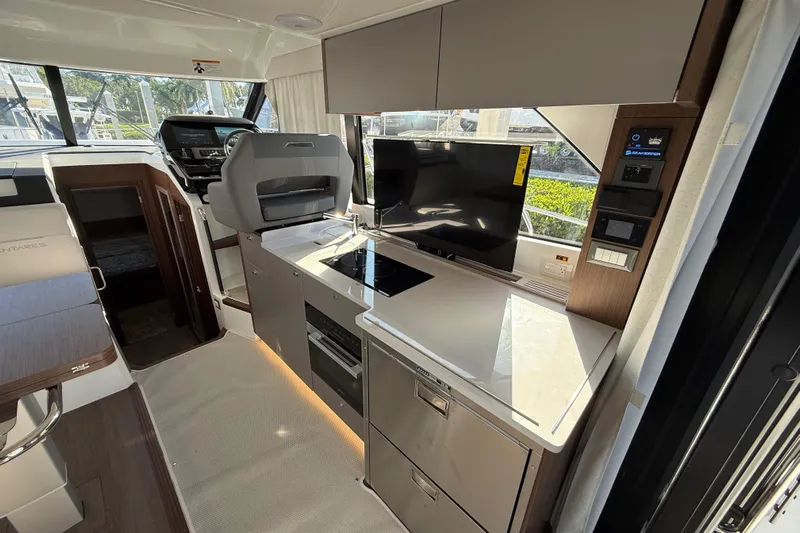  Yacht Photos Pics Modern interior of 2026 Beneteau Antares 12 yacht with sleek kitchen and navigation area.