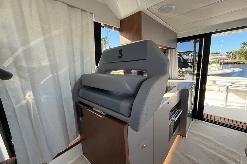  Yacht Photos Pics Interior of 2026 Beneteau Antares 12 yacht with modern helm seat and kitchenette.