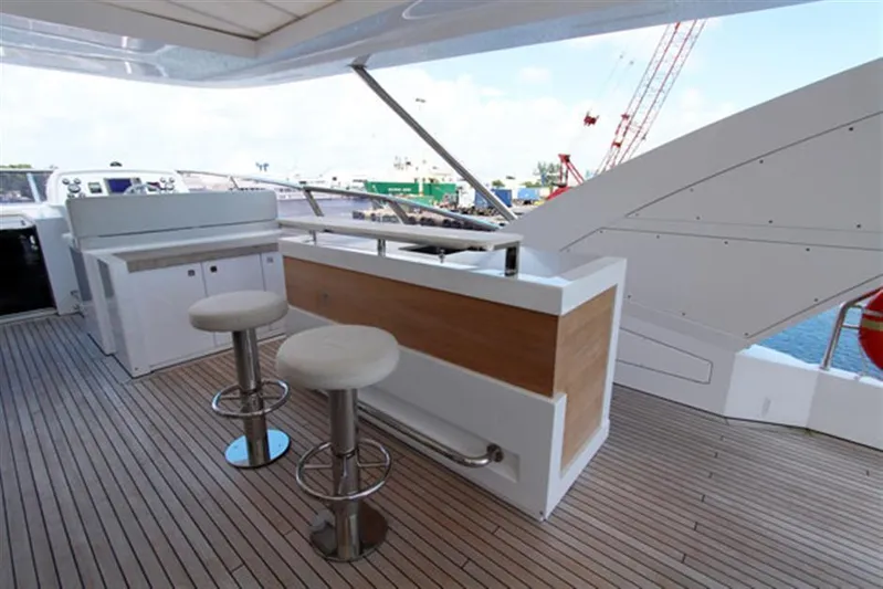 La Tache Yacht Photos Pics Outdoor bar area on 2014 Azimut 100 Grande yacht with stools and wooden deck.