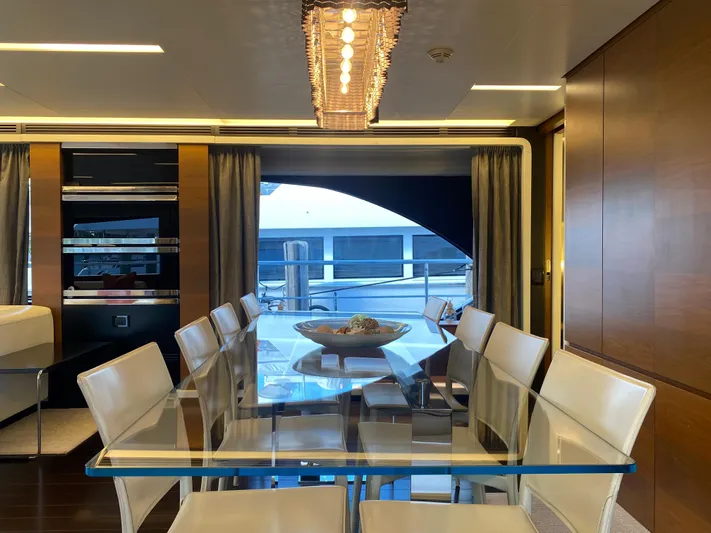 La Tache Yacht Photos Pics Luxurious dining area on a 2014 Azimut 100 Grande yacht with glass table and modern decor.