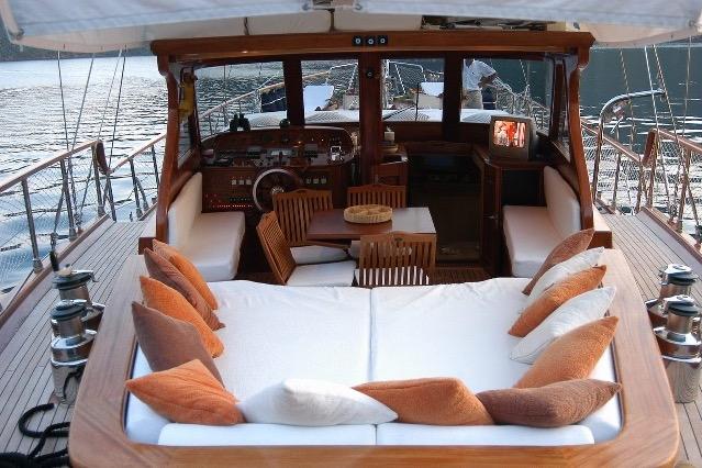 Luxurious custom yacht interior with cushioned seating, wooden table, and scenic water view, 2006 model.