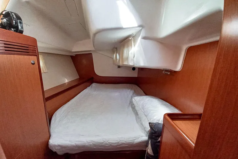  Yacht Photos Pics Cozy cabin interior of 2007 Beneteau 46 sailboat with wooden finish and comfortable bedding.