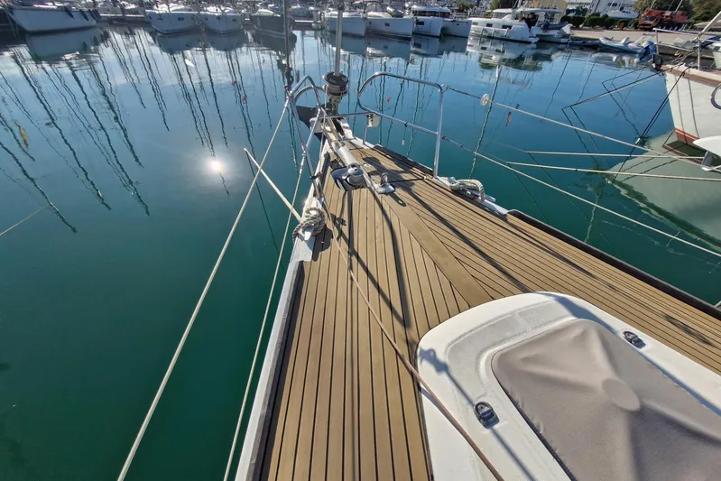  Yacht Photos Pics Deck view of a 2007 Beneteau 46 sailboat in a marina, reflecting on calm water.