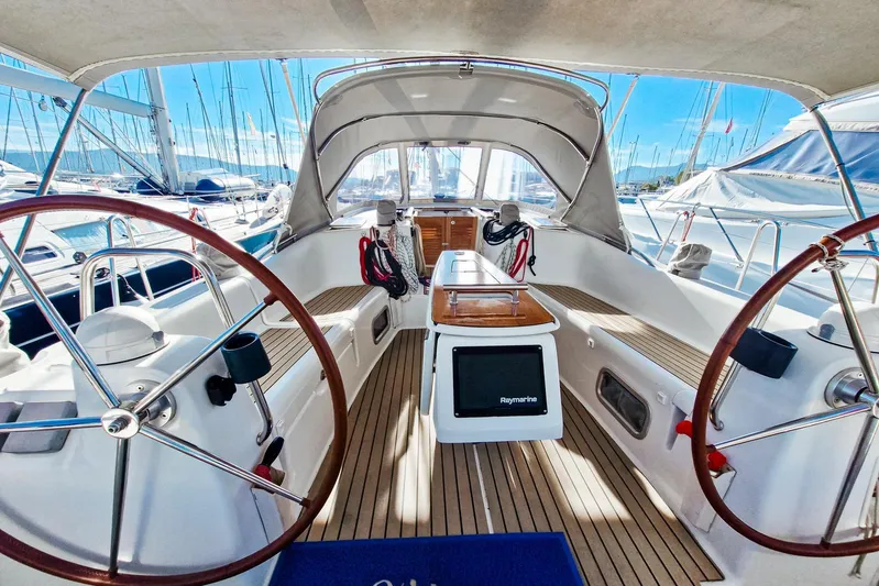  Yacht Photos Pics 2007 Beneteau 46 sailboat cockpit with dual steering wheels and teak flooring in marina.