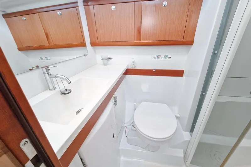  Yacht Photos Pics Bathroom interior of 2007 Beneteau 46 yacht with sink, toilet, and wooden cabinets.