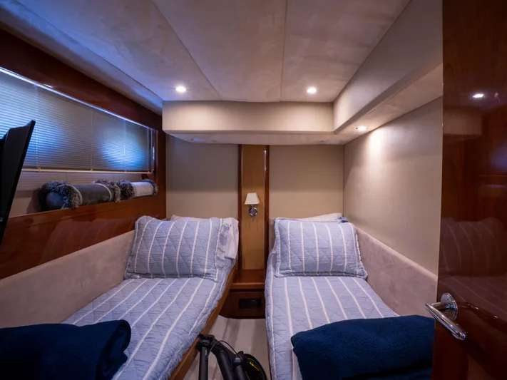 Road Runner Yacht Photos Pics Twin cabin interior of 2008 Princess V53 yacht with striped bedding and soft lighting.