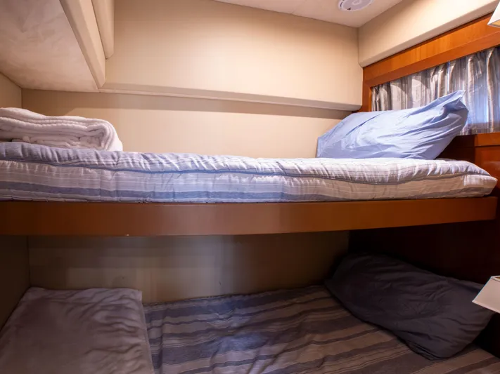 Road Runner Yacht Photos Pics Bunk beds in 2008 Princess V53 yacht cabin with cozy bedding and soft lighting.