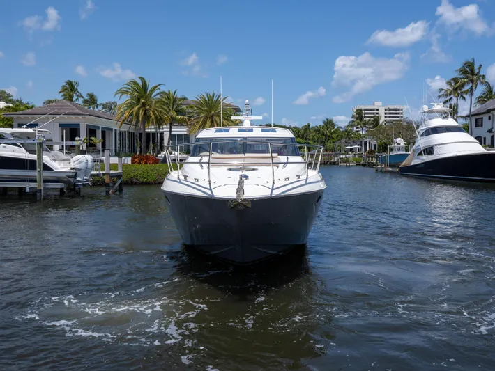 Road Runner Yacht Photos Pics 2008 Princess V53 yacht cruising in a sunny marina with palm trees and blue sky.
