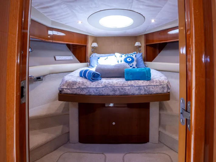 Road Runner Yacht Photos Pics Luxurious cabin interior of 2008 Princess V53 yacht with cozy bedding and elegant wood finishes.