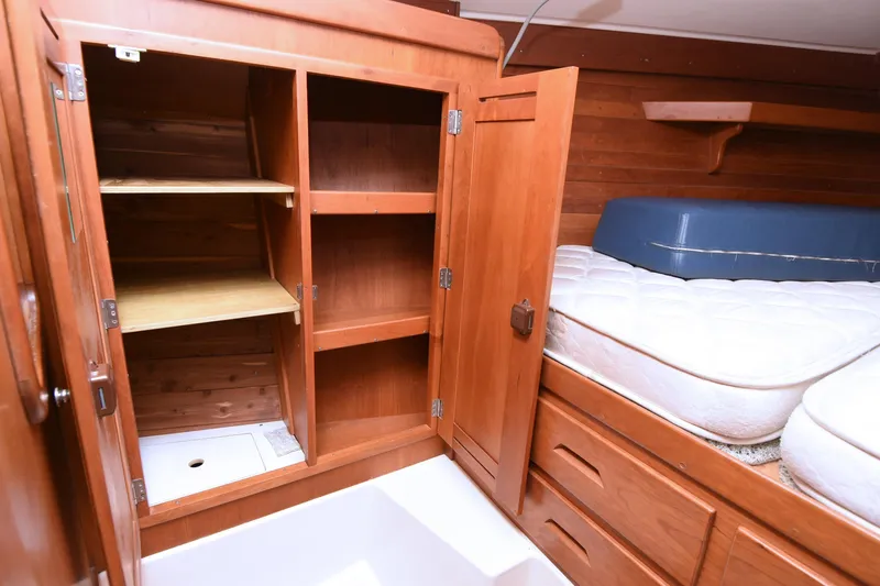 Makasi Yacht Photos Pics Wooden interior of 2008 Tartan 4100 yacht with open storage and bed.