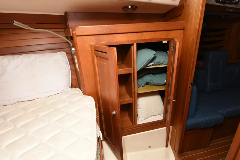Makasi Yacht Photos Pics 2008 Tartan 4100 yacht interior with wooden cabinet and bedding storage.