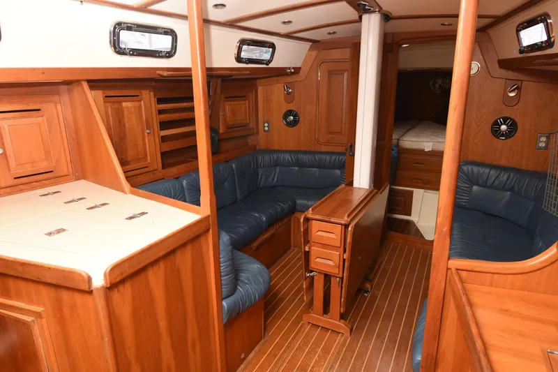 Makasi Yacht Photos Pics Interior of 2008 Tartan 4100 sailboat with wooden cabinetry and blue seating.